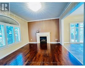 A living room with a fireplace and wood flooring.
