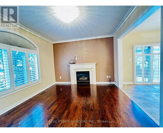 A living room with a fireplace and wood flooring.