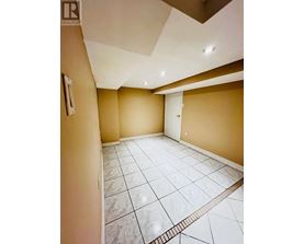A spacious room with a marble floor and a skylight.