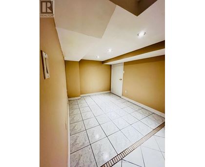 A spacious room with a marble floor and a skylight.