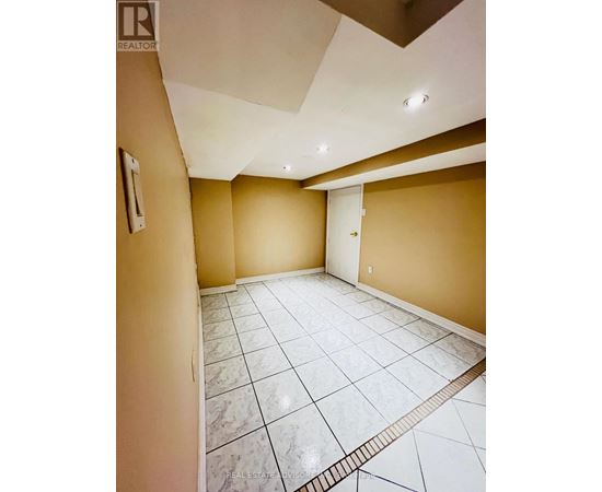 A spacious room with a marble floor and a skylight.