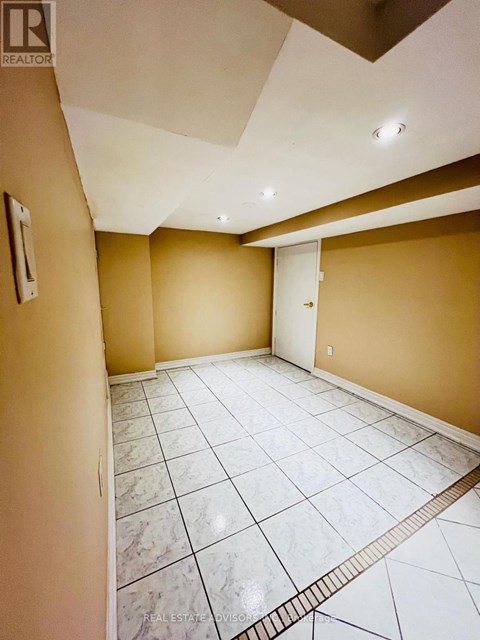 A spacious room with a marble floor and a skylight.