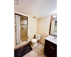A bathroom with a toilet, sink, and shower.