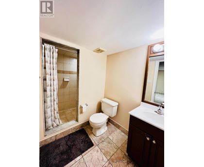A bathroom with a toilet, sink, and shower.