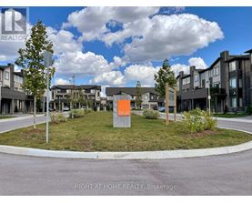 A real estate sign in front of a housing development.
