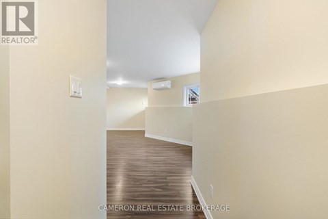 A hallway with a wooden floor and white walls.