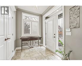 A hallway with a bench and a window with shutters.