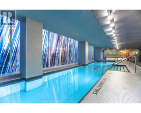 A swimming pool in a room with a glass wall.