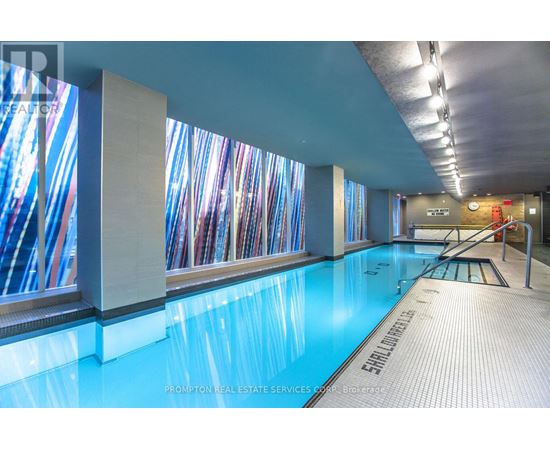 A swimming pool in a room with a glass wall.