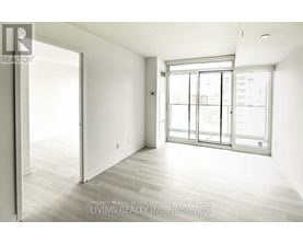 A spacious room with a sliding glass door leading to a balcony.