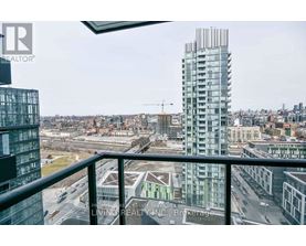 A view from a balcony overlooking a city with a tall building in the background.