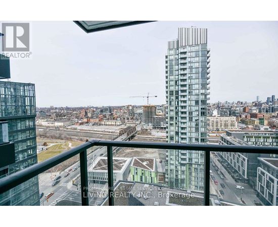 A view from a balcony overlooking a city with a tall building in the background.