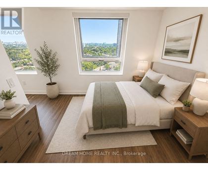 A bedroom with a large bed, a window with a view, and a nightstand with a lamp.