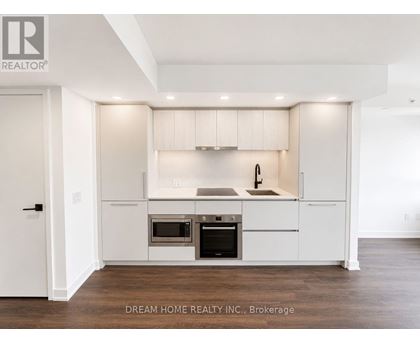 A modern kitchen with white cabinets and stainless steel appliances.