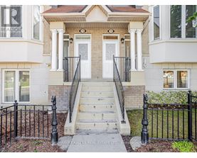 A house with a front porch and a black fence.