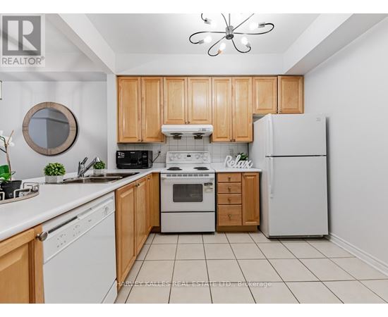 A kitchen with wooden cabinets and white appliances.