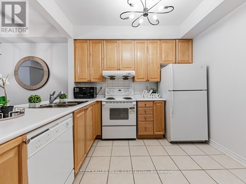 A kitchen with wooden cabinets and white appliances.