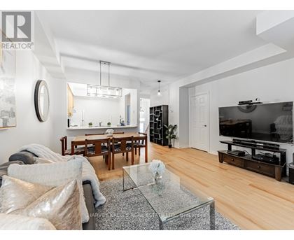 A modern living room with a glass coffee table and a flat screen TV.