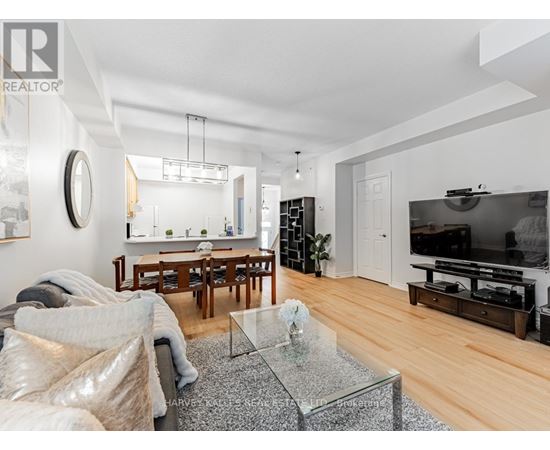 A modern living room with a glass coffee table and a flat screen TV.