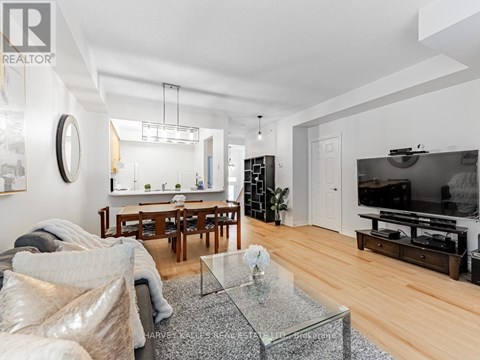 A modern living room with a glass coffee table and a flat screen TV.