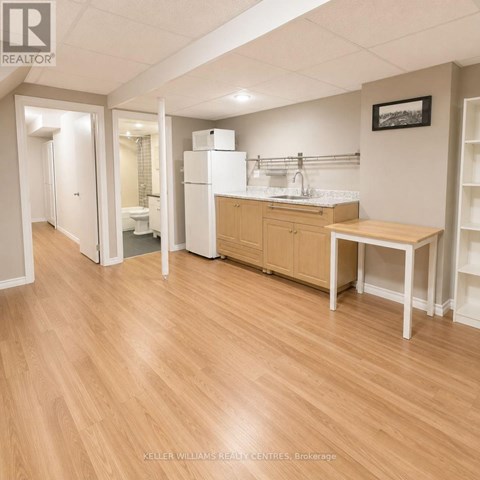 A kitchen area with a table, chairs, and a refrigerator.
