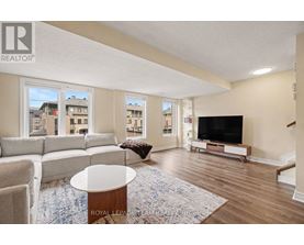 A living room with a white couch, a coffee table, and a television.