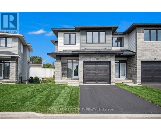 A modern house with a grey front yard is for sale.