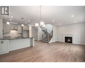 A spacious living room with a staircase and a fireplace.