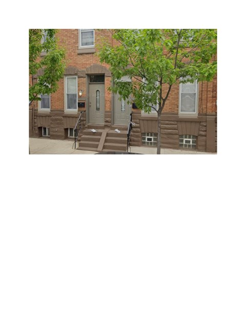 A brown building with a grey door and steps leading up to it.