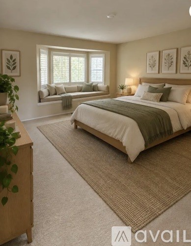 A bedroom with a large bed and a window seat.