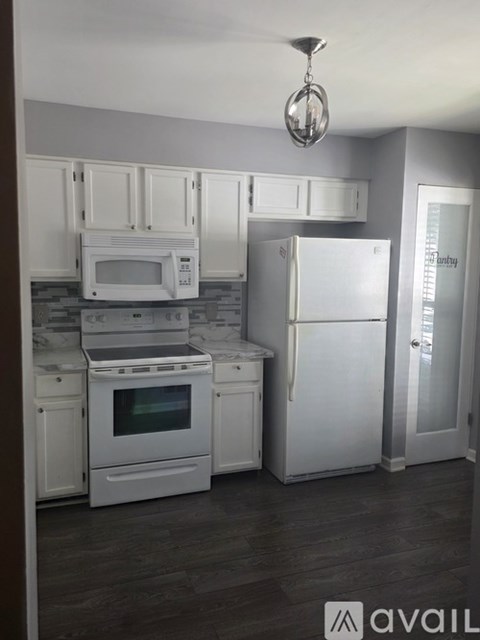 A kitchen with white appliances and cabinets.