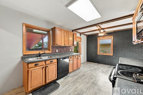 A kitchen with wooden cabinets and a black stove top oven.