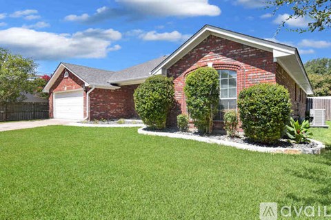 A red brick house with a white garage door and a white window.