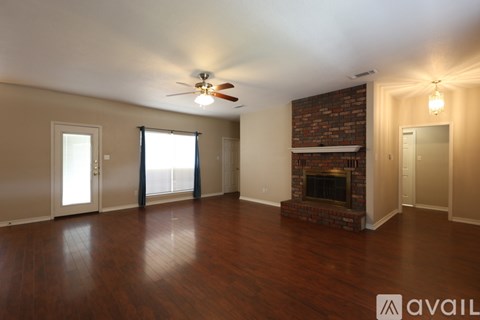 A living room with a fireplace and a ceiling fan.
