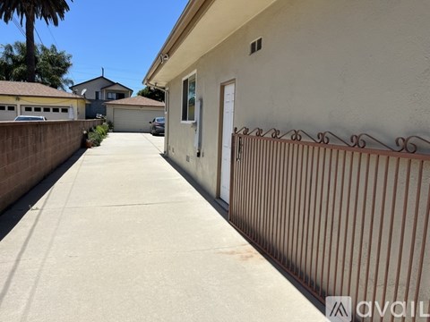 A long concrete driveway leads to a white door.