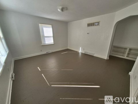A spacious room with a window and a white ceiling.
