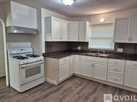 A kitchen with white appliances and cabinets.