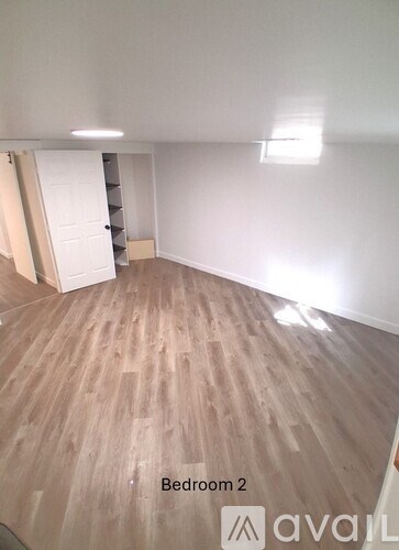 Bedroom 2 has a wooden floor and a white door.