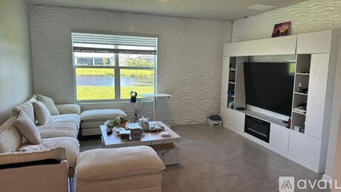 A living room with a couch, a coffee table, and a television.