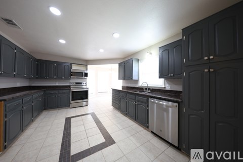 A kitchen with black cabinets and a white floor.
