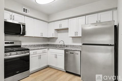 A kitchen with white cabinets and stainless steel appliances.