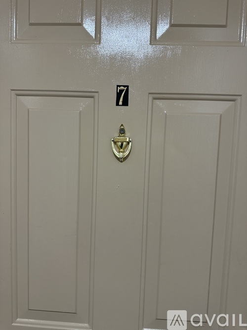 A white door with a brass handle and a number 7 on the side.