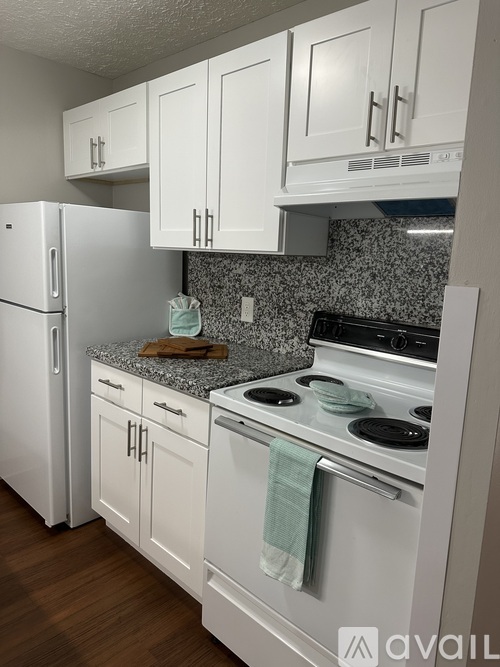 A kitchen with white appliances and cabinets.