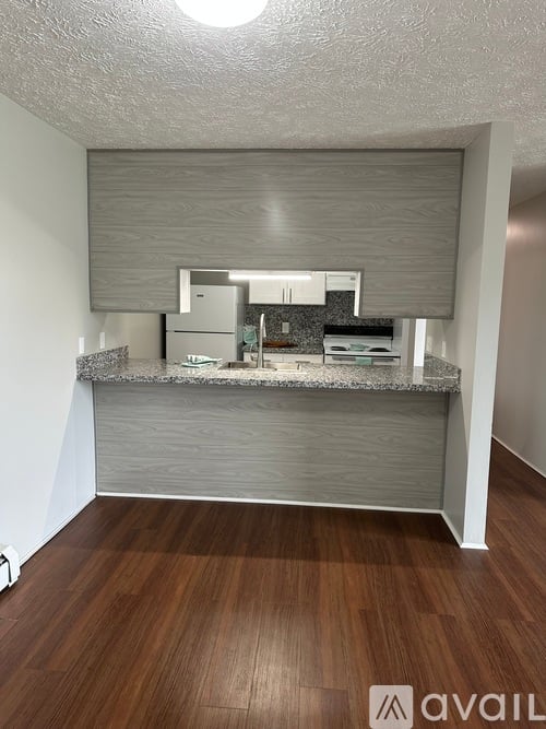 A kitchen with a countertop and cabinets under a window.