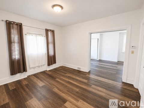 A room with wooden flooring and white walls.