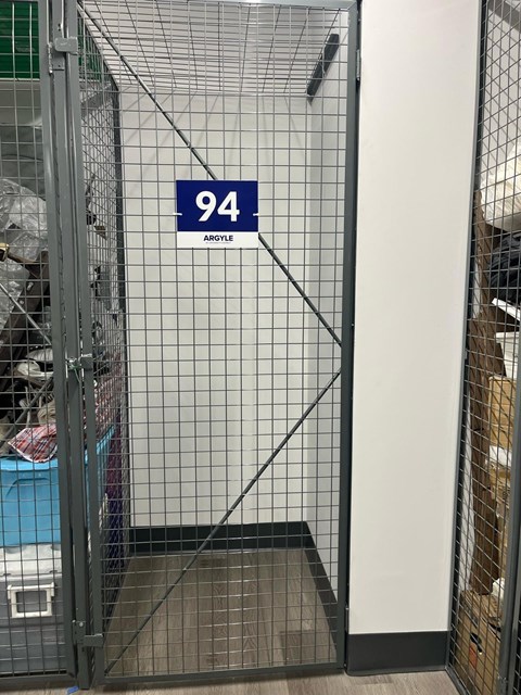 A wire mesh gate with a sign that says 94 on it.
