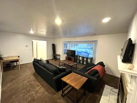 A living room with a black couch and a television.