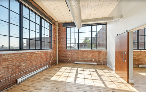 A room with a brick wall and a wooden floor.