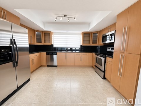 A kitchen with wooden cabinets and black appliances.