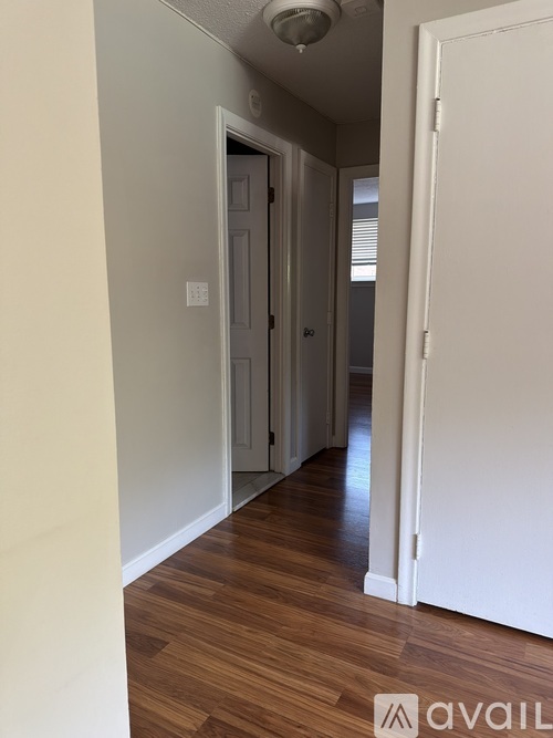 A hallway with a white door on the right and a white door on the left.